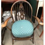 An Ercol mahogany stained cottage armchair with green patterned seat pad