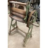 A Popula green metal mangle with white enamel top and on castors - roller length 46cm