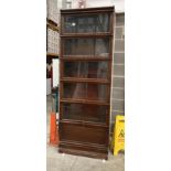 A GLOBE WERNICKE OAK STANDING BOOK CASE with five glazed sections over single door single drawer