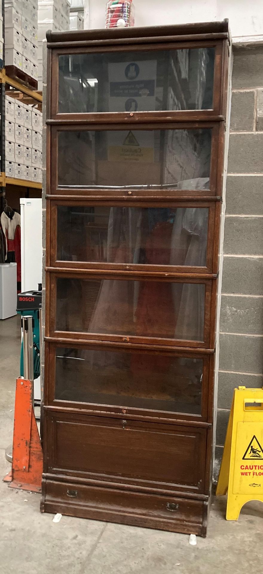 A GLOBE WERNICKE OAK STANDING BOOK CASE with five glazed sections over single door single drawer