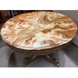 A brown patterned circular coffee table 62cm dia on brass frame