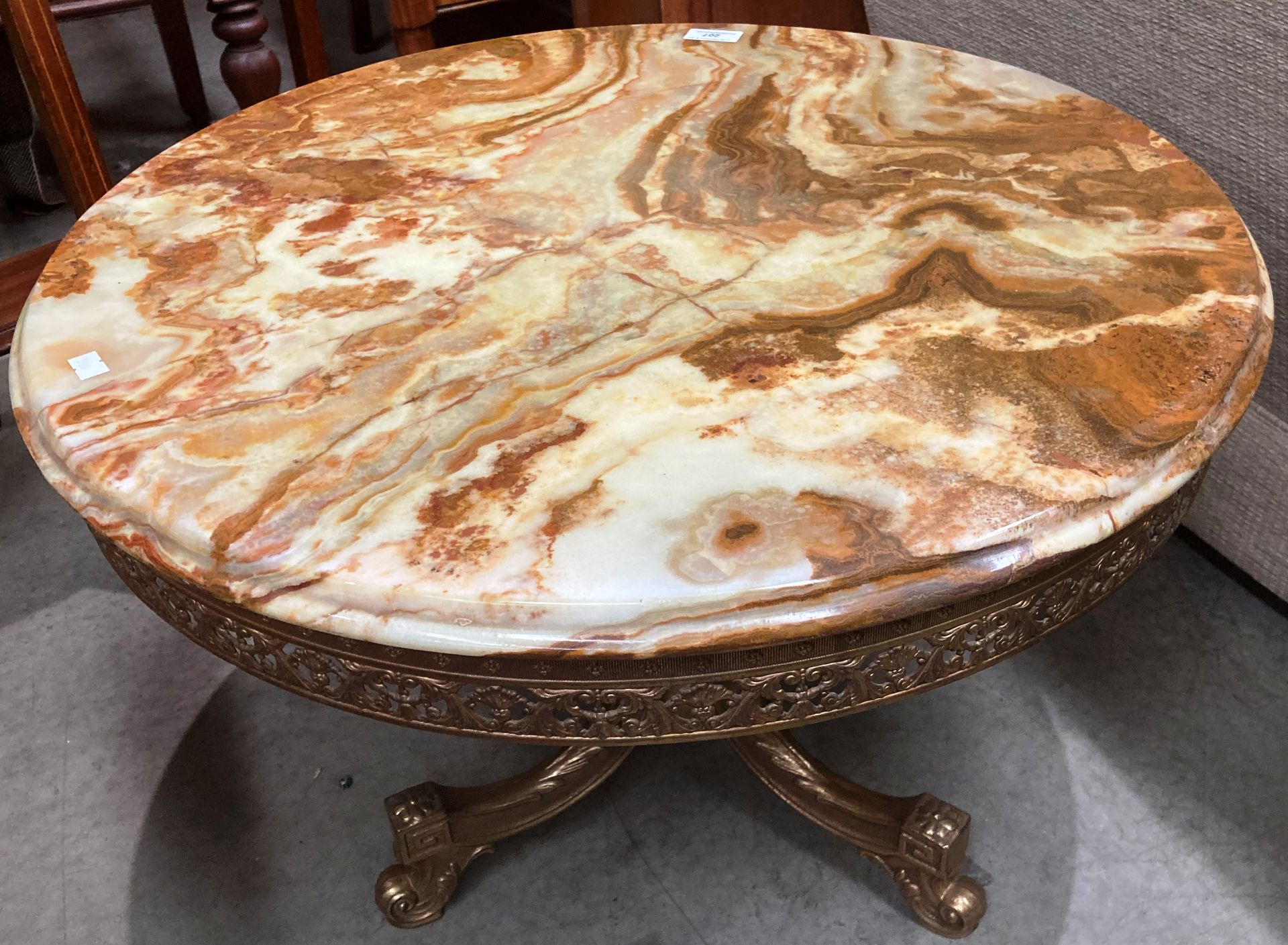 A brown patterned circular coffee table 62cm dia on brass frame