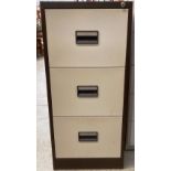 A brown and beige metal three drawer filing cabinet