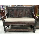 A carved oak settle 124cm