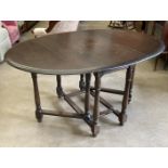 An oak drop leaf oval dining table 107 x 155cm extended
