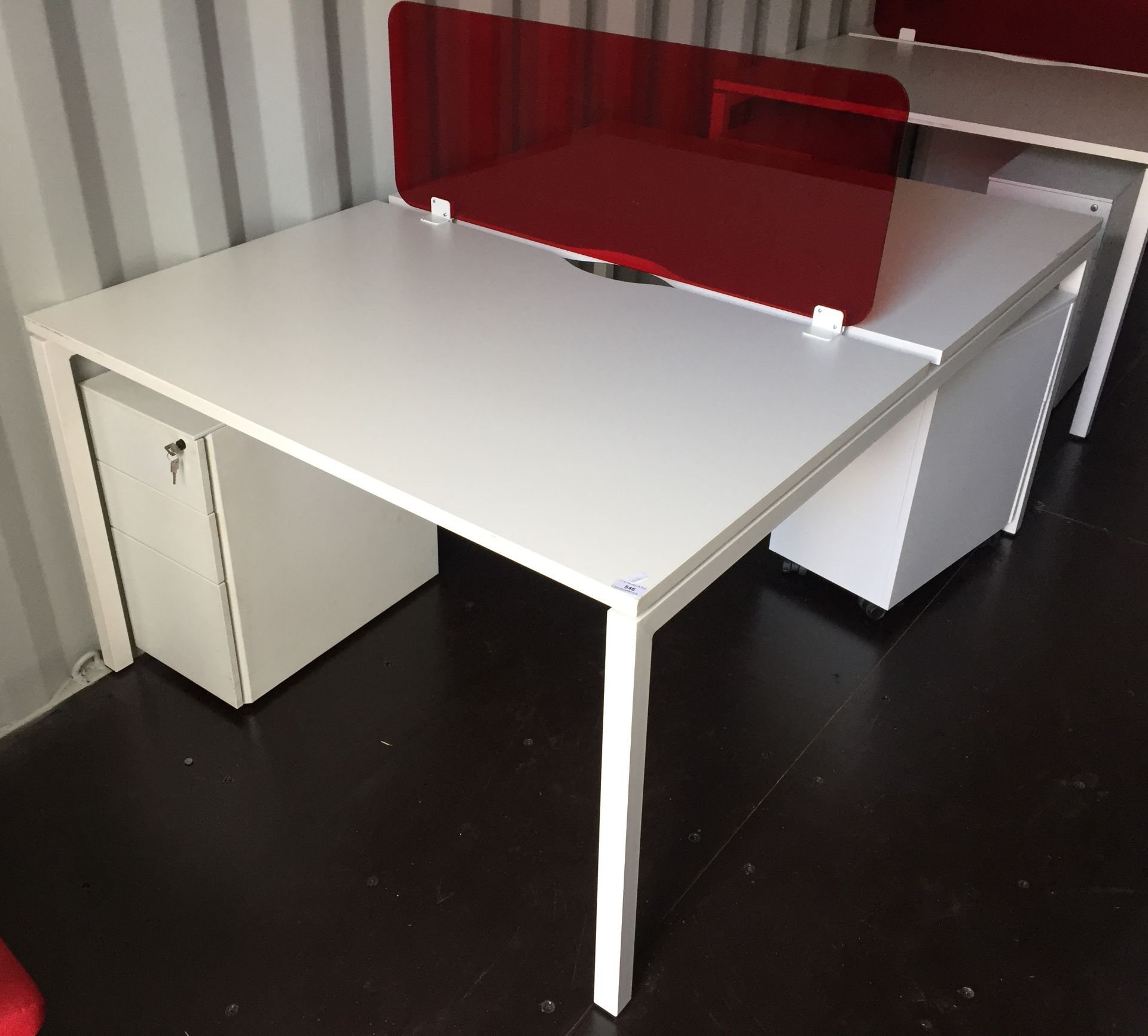 White steel framed double sided desk pod with two 3 drawer white metal mobile pedestals and a red