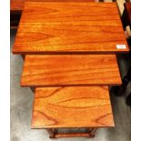 A stained finish nest of three coffee tables