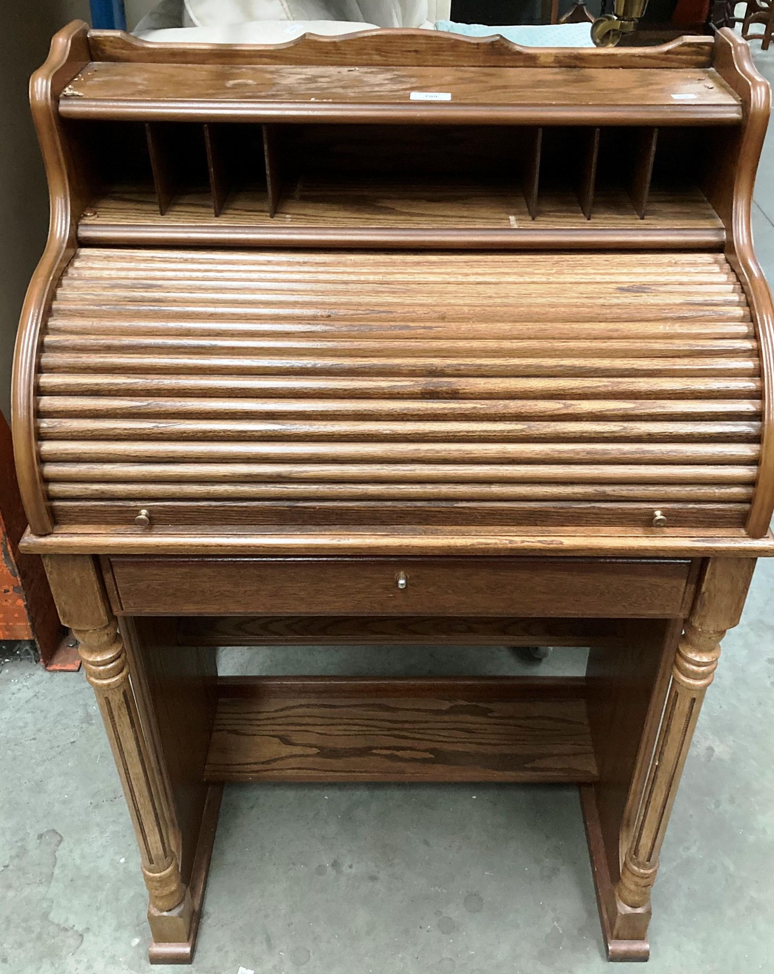 A small light oak single drawer roll top desk 68cm x 110cm high