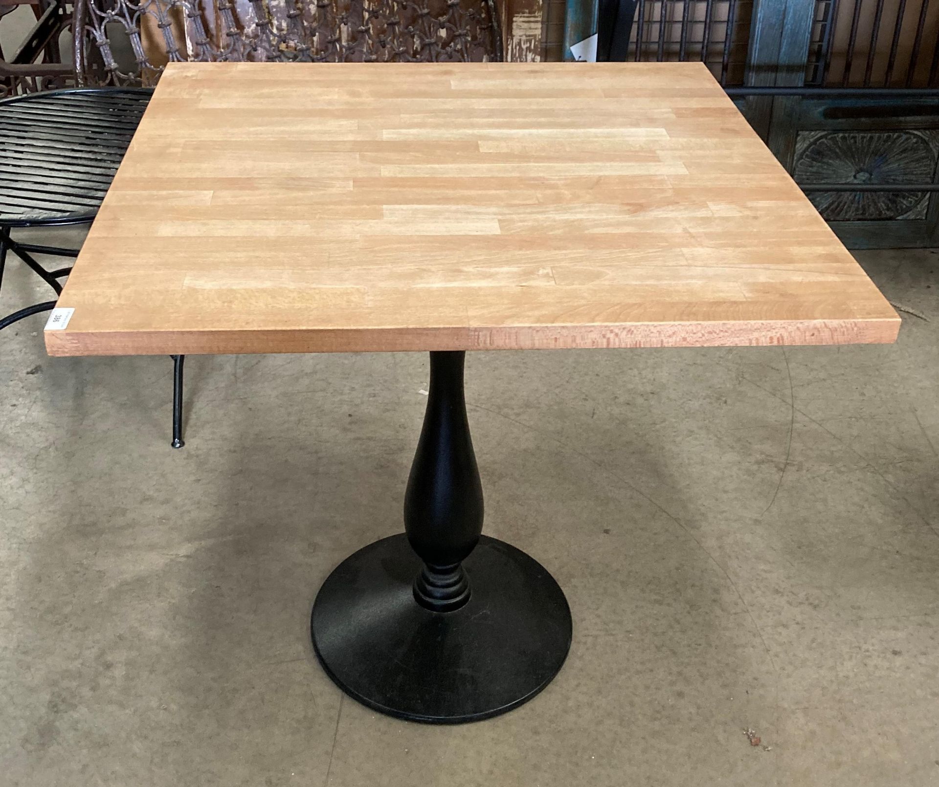 Light wood topped table with a black single column metal base 75 x 77 x 75cm high