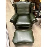 A dark green leather wing back armchair with matching pouffe - please note no fire certificates,