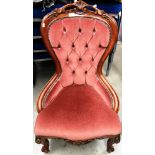 A reproduction mahogany framed nursing chair with pink dralon upholstery