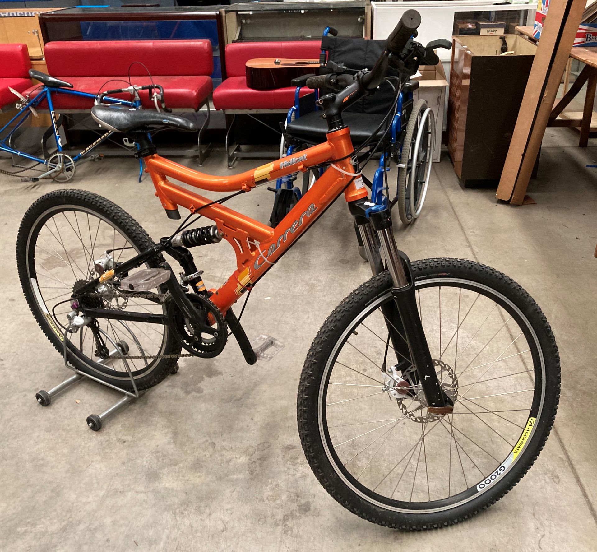 A Carrera Hellcat Shimano Diore 18 speed front and rear suspension mountain bike in orange with