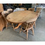 An oval pine dining table on centre column with four legs,