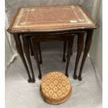 A nest of three coffee tables with brown tooled leather effect tops with inset glass and a small
