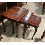 A mahogany finish reproduction nest of three coffee tables