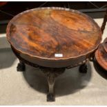 A walnut circular coffee table with pie crust edging on cabriole legs on claw and ball feet