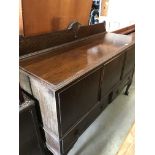 An oak three door (two locked), two drawer sideboard on claw and ball feet,