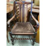 An oak armchair with brown upholstered seat