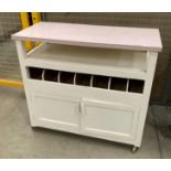 A white painted wooden cutlery trolley with pink formica top 92 x 42cm