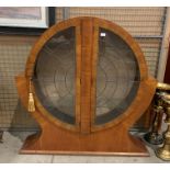 An Art Deco circular china cabinet with leaded glazed doors, two glass shelves and a key,