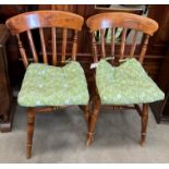 Pair of pine spindle back dining chairs with green upholstered pad seats