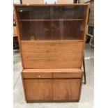 A teak finish wall unit with glass sliding doors over fall flap and two drawer two door base 92 x