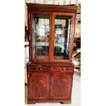 A mahogany finish wall unit with two glazed doors over two drawer, two door base,
