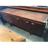 A teak four door (one fall flap) single drawer sideboard (slight damages to back right hand side),
