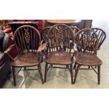 A set of six dark oak wheel back dining chairs including two carvers