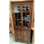 An oak freestanding corner cabinet with two upper glazed doors over two door base 70 x 172cm high