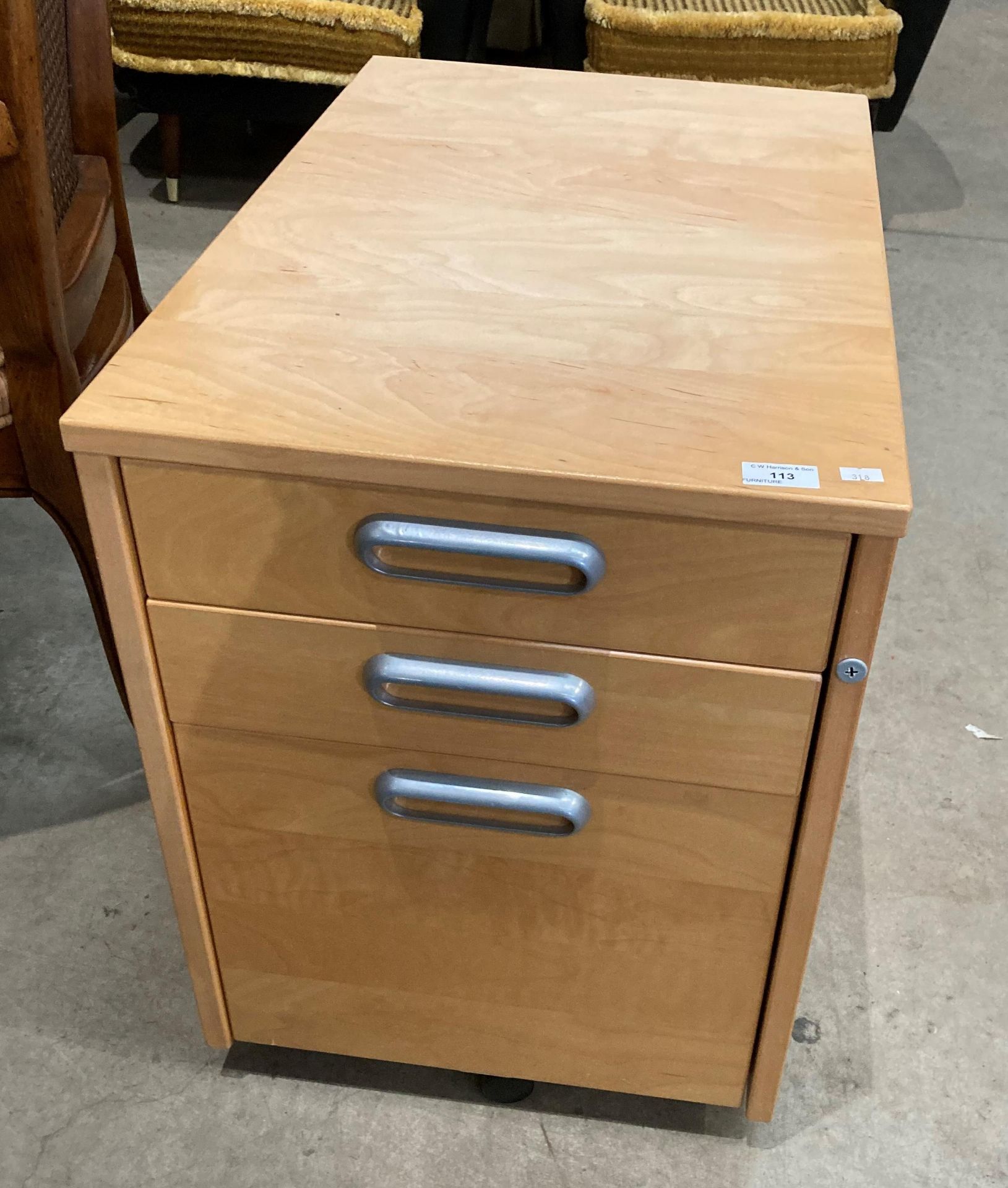 A light pine finish mobile three drawer pedestal