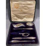 A silver manicure set in a fitted black case - missing part of pair of scissors