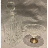 A glass decanter and a glass dish with silver rim