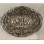 A silver tray with a scene of merriment in relief to the base, 27cm, total approximate weight 10.