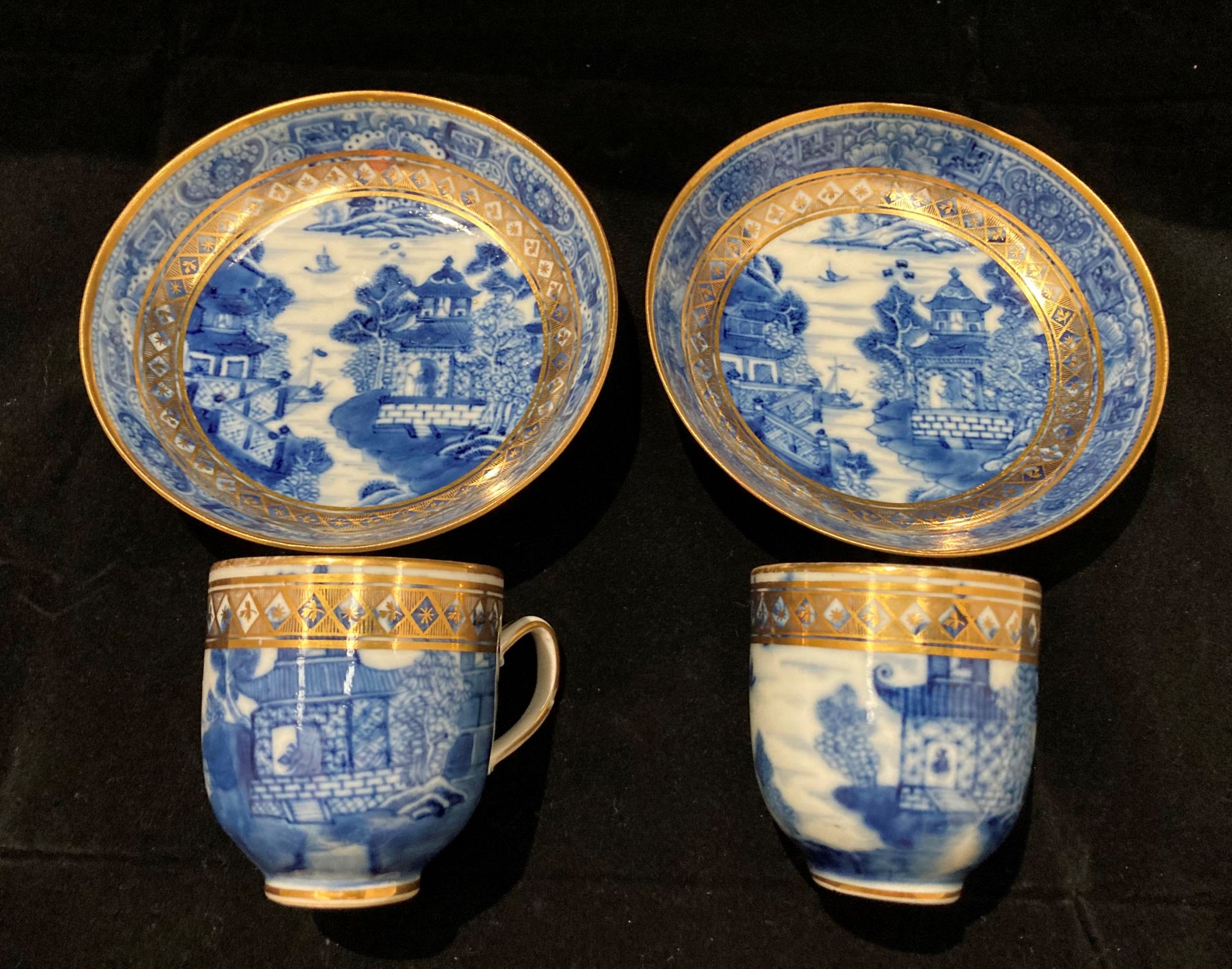 Two blue and gilt oriental patterned cups with matching bowls/saucers (four pieces)