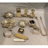 Contents to tray - a silver three piece condiment set, a silver topped smelling salts glass bottle,