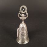 A Berthold Muller silver bell in the form of a lady holding a wreath,