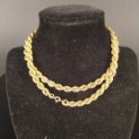 An unmarked yellow metal rope effect necklace with replacement base metal clasp and links,