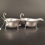 A pair of Aspreys silver sauce boats with wavy cut rim on three paw feet,