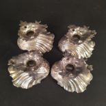 A set of four Victorian silver scallop form salts on naturalistic wave form bases,