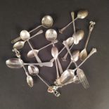 A collection of silver and white metal spoons including enamelled souvenir spoons,