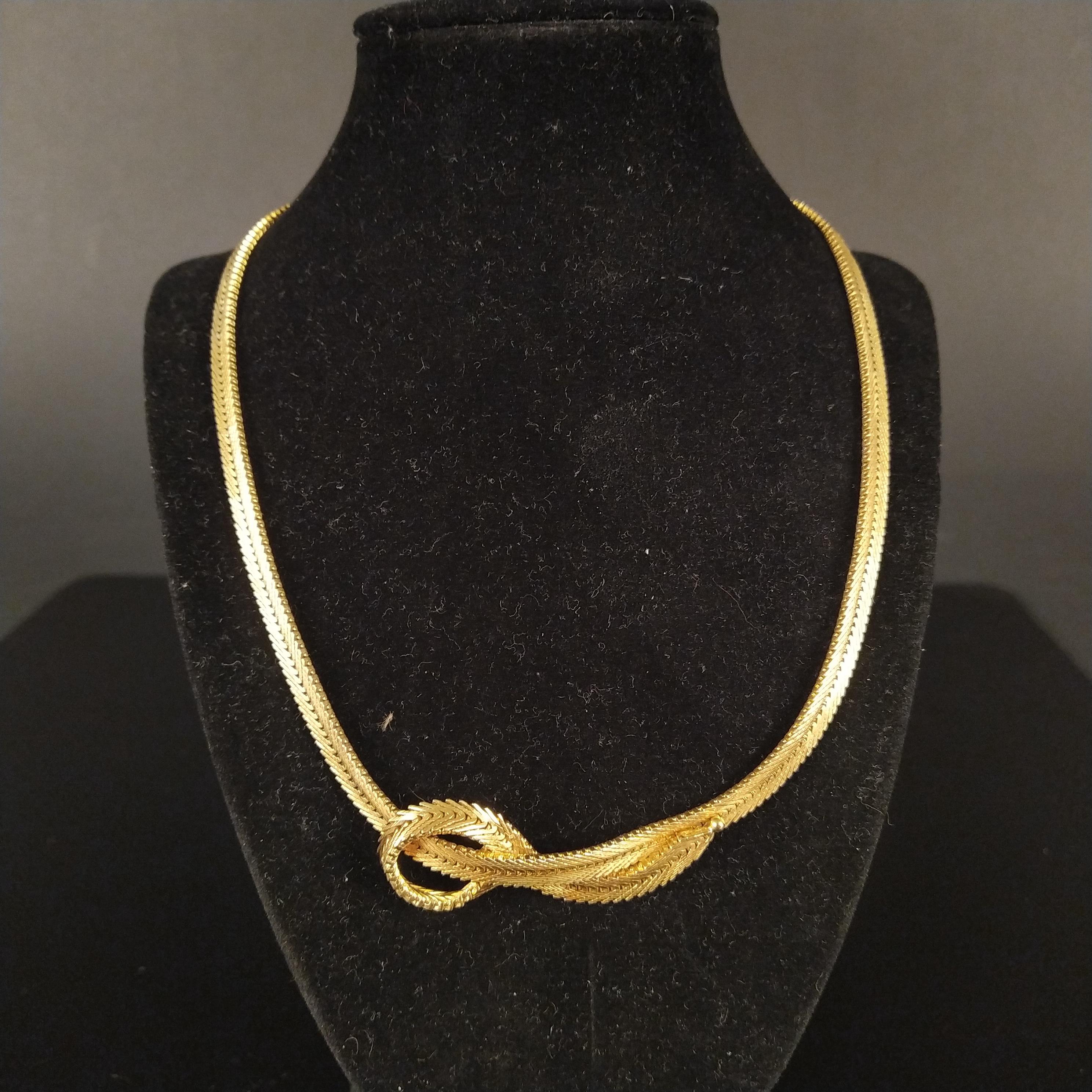 A heavy 18ct gold V link necklace with knot effect to centre,