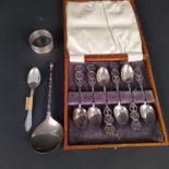 A Victorian silver spoon with ornate handle, a silver napkin ring,