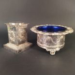 A large ornately decorated silver plated dish with blue glass insert,