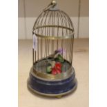A 19th Century style bird in cage automation with brass cage and blue base,