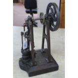 A cast iron and steel steam engine standing on mahogany base