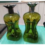 A pair of green glass silver rimmed decanters (lacking stoppers),