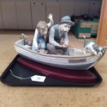 A large Lladro porcelain figure group 'Fishing with Gramps' in Paloma boat on a wooden display