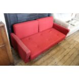 A vintage c1960's red two seater sofa on legs