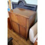 An unusual 1930's oak combination cupboard/desk with fall front fitted interior above two door